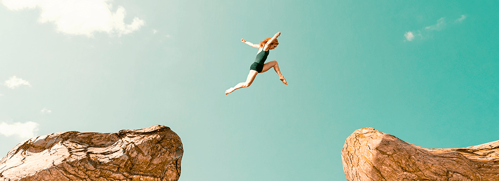 Sportlerin springt zwischen zwei Felsen - Herausforderungen