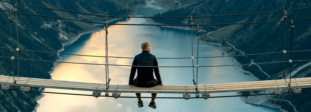 Sportler auf Hängebrücke in den Bergen - Verlässlichkeit