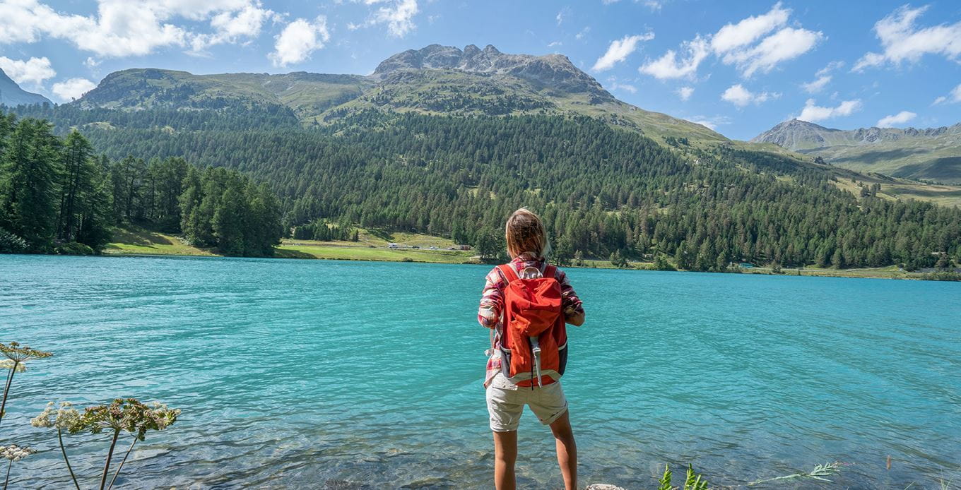 Wanderin mit Blick auf klaren Bergsee